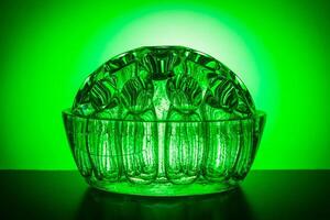 dekorativ halvcirkelformig glas vas på en bakgrund av grön lutning foto