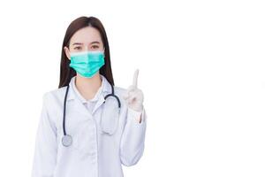 ung professionell asiatisk kvinna läkare vem bär medicinsk ansikte mask sudd handske till skydda hälsa är pekande upp till närvarande något medan isolerat vit bakgrund. foto