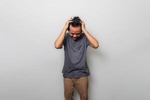 ett asiatisk man i grå är betonade eller har en huvudvärk tycka om frustration foto