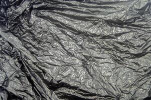 textur av svart plast väska skrynkliga. kopia Plats foto