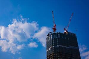 kran på de under konstruktion Bakom de blå himmel i tokyo foto