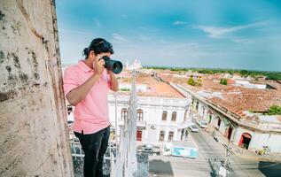 turist fotografering de gator av granada från de la merced synpunkt. turist man tar foton av de tak av de kolonial hus i granada