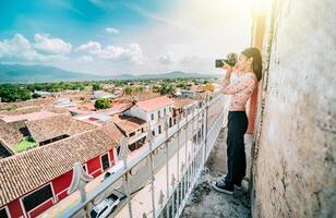 turist fotografering de gator av granada från de la merced synpunkt. turist flicka tar foton av de tak av de kolonial hus i granada