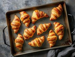 färsk franska croissanter på en bakning bricka, bara bakad i de ugn. textur bakgrund. estetisk närbild Foto