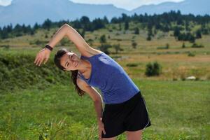 fast besluten sträcka. atletisk kvinna omfamnar efterkörning flexibilitet i natur. foto