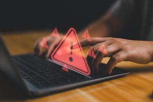 användare är använder sig av dator med triangel varning varning tecken för underrättelse fel och underhåll begrepp. hacker attacker och dataintrång data, cyber brottslighet, ransomware, nätfiske, spionprogram, Cybersäkerhet. foto