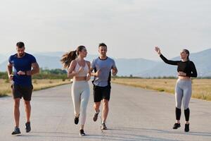 en grupp av vänner hävdar en friska livsstil förbi löpning utomhus på en solig dag, bindning över kondition och njuter de energigivande effekter av övning och natur foto