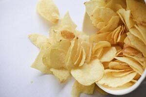 utsökt saltade potatis pommes frites i en kartong burk på en vit bakgrund. snabb mat. foto