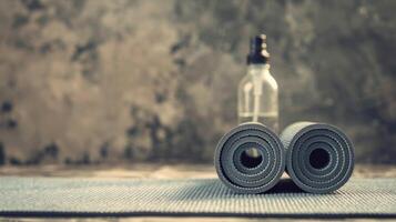 flaska av vatten Nästa till två rullad upp yoga mattor foto