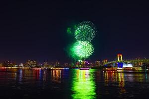 en natt fyrverkeri nära regnbåge bro på de urban stad i tokyo foto