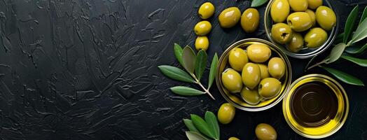 oliver och oliv olja i skålar på en svart bakgrund foto