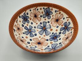isolerat vit handmålad keramisk skål med blommig mönster och vibrerande färger foto