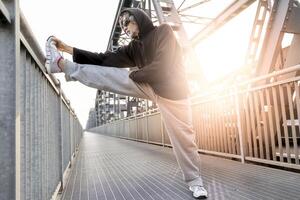 idrottare håller på med stretching på metall bro. friska livsstil och sport begrepp foto