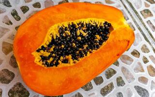 halv papaya i hand med bakgrund i Mexiko. foto