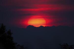 eldig solnedgång över silhouetted bergen foto