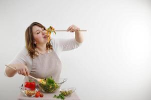 rolig glad kvinna äter sallad trä- sked saker del av mat vikt förlust reklam friska mat vegetarian mat kvinna i kropp full saftig baner vit bakgrund glas Bra aptit foto