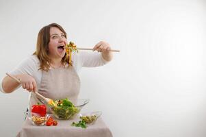 rolig glad kvinna äter sallad trä- sked saker del av mat vikt förlust reklam friska mat vegetarian mat kvinna i kropp full saftig baner vit bakgrund glas Bra aptit foto