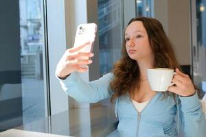 Kafé, smartphone selfie och svart kvinna med kaffe för social media restaurang recension, marknadsföring och gen z livsstil. influencer kund på kaffe affär använder sig av telefon fotografi för uppkopplad profil foto