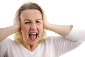 frustrerad ung kvinna innehav händer på öron, förvaring ögon stängd och gråta. foto