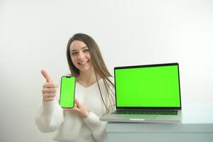 chromakey. bärbar dator och telefon med grön skärm på trä- tabell i Hem interiör. foto