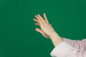 en kvinna händer smetande grädde på de handflatan av henne hand mot de borsta. vårdad händer, naturlig kort naglar, på en ljus bakgrund. foto