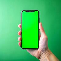 hand innehav smartphone med grön skärm på en grön bakgrund foto