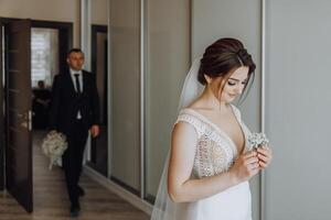 en brud är få redo för henne bröllop och är innehav en blomma i henne hand foto