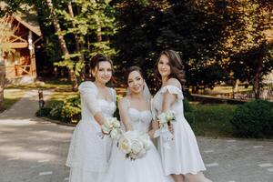 tre kvinnor i vit klänningar utgör för en Foto i främre av en hus