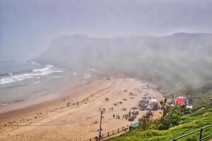 dimmig strand med människor avkopplande och tält i tynemouth strand foto