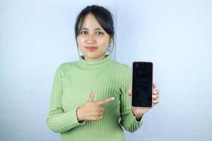 ung skön asiatisk kvinna innehav tom skärm smart telefon på vit bakgrund foto
