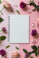 spiral anteckningsbok omgiven förbi blommor på rosa bakgrund foto