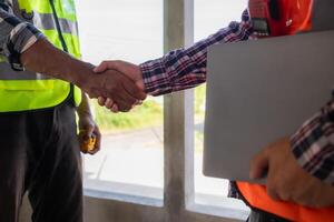 Bakom de scener förman bär reflekterande väst och hård hatt inspekterar konstruktion webbplats till säkerställa konstruktion möter teknik lagets design planer och för de skönhet och säkerhet av invånare. foto