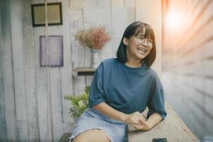 asiatisk tonåring skrattar med lycka ansikte i levande café foto