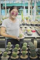 kvinna toothy leende med lycka håller potten med kaktus