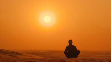 en silhuett av en person sitter på en öken- dyn tittar på de Sol handfat Nedan de dimmig orange himmel. . foto