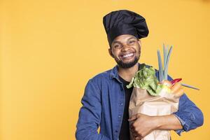 afrikansk amerikan manlig kock uppköp färsk specerier till förbereda en särskild vegan recept, känsla upphetsad handla om hållbar livsstil och friska äter med etiskt kommer från mat. noll avfall. foto