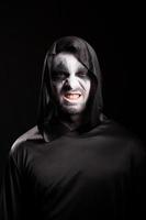 grim reaper med ett läskigt ansikte isolerat över svart bakgrund foto