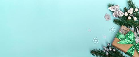 god Jul och Gott Nytt År. platt lägga av en gåva med ett grönt prickigt band och ornament på en blå bakgrund. julkort kopia utrymme närbild