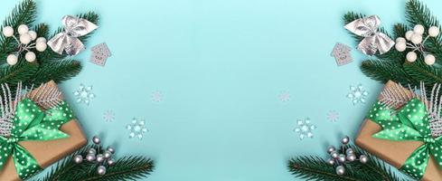 god Jul och Gott Nytt År. platt lägga av en gåva med ett grönt prickigt band och ornament på en blå bakgrund. julkort kopia utrymme närbild