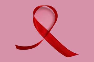 röd aids medvetenhet band på rosa bakgrund. närbild, kopiera utrymme.