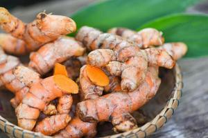 gurkmeja på korg, färsk gurkmejarot och för naturmedicin ört och lagad ingrediensmat. foto