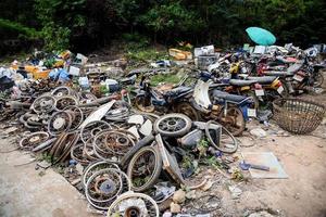 avfallsskrot med motor motorcykel gammal rost, hög med gamla rostiga metallfälgar i bilens trumma hjul fordonsavfall foto
