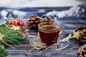en kopp aromatiskt kaffe med farinsocker, juldekorationer, grenar av en julgran. semester koncept nytt år. på en trä bakgrund. foto