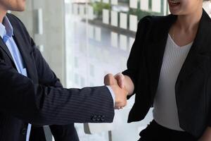 Lycklig kaukasien manlig och asiatisk kvinna hand skakning, framgångsrik affärsman handslag efter Bra handla för både företag, företag fusion och förvärv begrepp foto