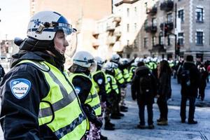 montreal, kanada 2 april 2015 - poliser gör en linje för att kontrollera demonstranterna foto