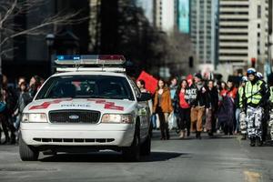 montreal, kanada 2 april 2015 - polisbil framför demonstranterna som kontrollerar trafiken foto