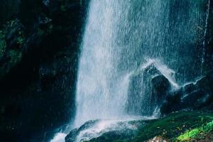 blått vatten vackert vattenfall i grön skog och sten i djungeln består av vatten foto