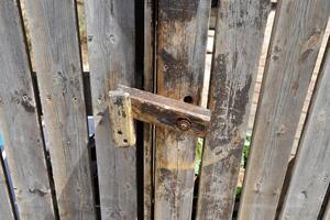 ett gammal metall låsa hänger på de staket. foto