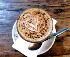mjölkkaffe med hjärtform som prickar choklad i en vit kopp
