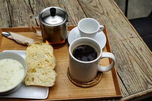 svart kaffe i en kopp med snacks bredvid foto